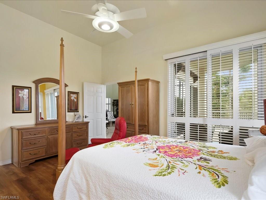 Bedroom featuring dark wood-style flooring, multiple windows, and a ceiling fan