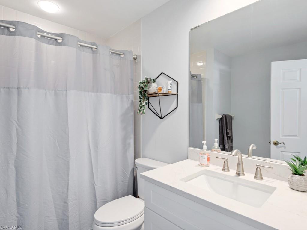 Bathroom featuring toilet and vanity with extensive cabinet space