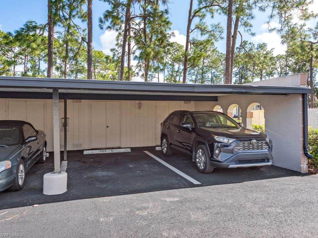 View of parking / parking lot with a carport