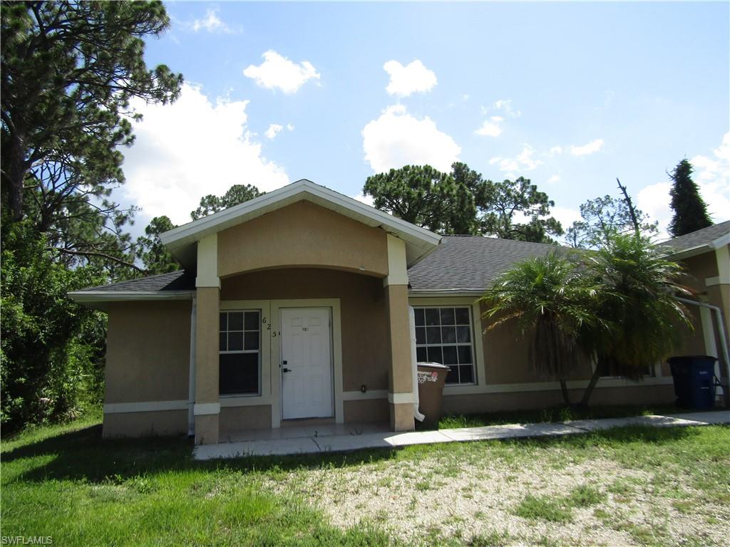 Stucco exterior with a covered entry, white paneled door, and multiple windows