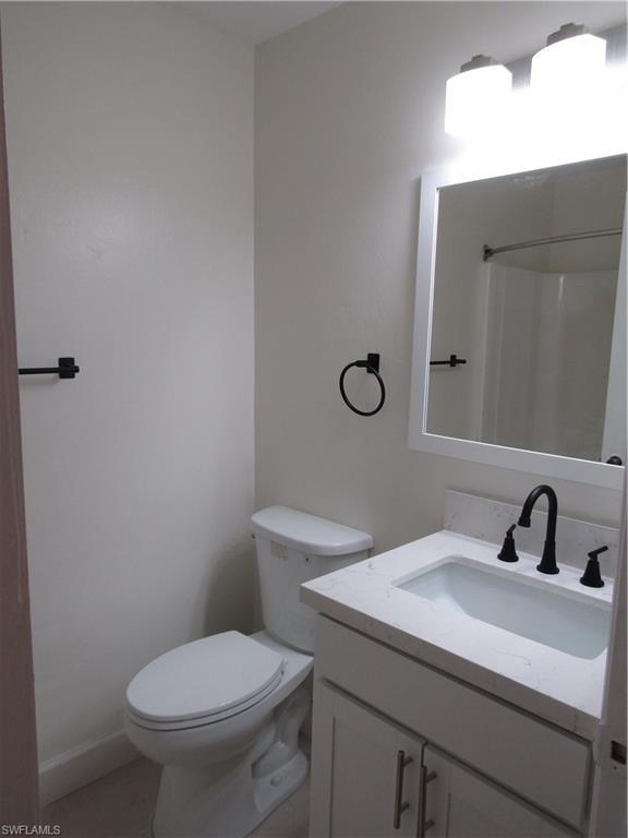 Bathroom featuring a white vanity with an integrated sink, a light-toned countertop, and matte black fixtures