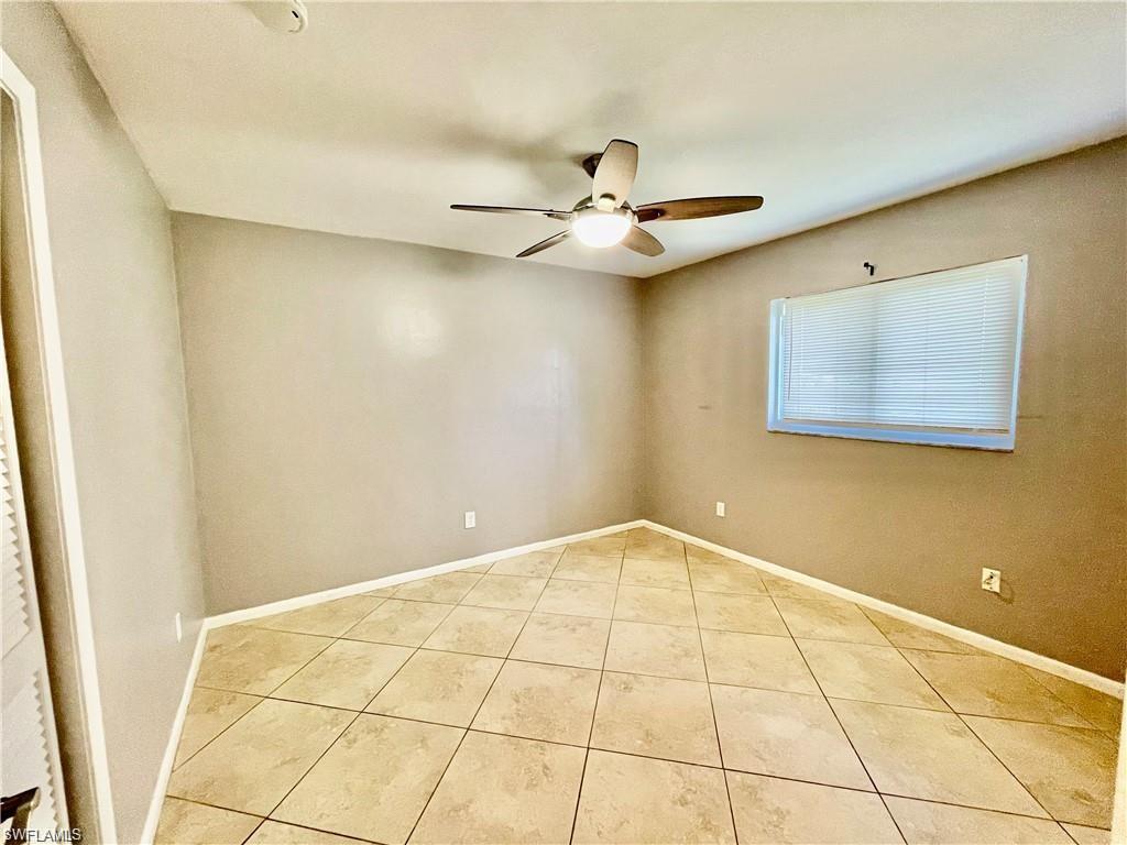 Room featuring ceramic tile flooring, a ceiling fan with integrated lighting, a window with horizontal blinds, and a neutral wall color