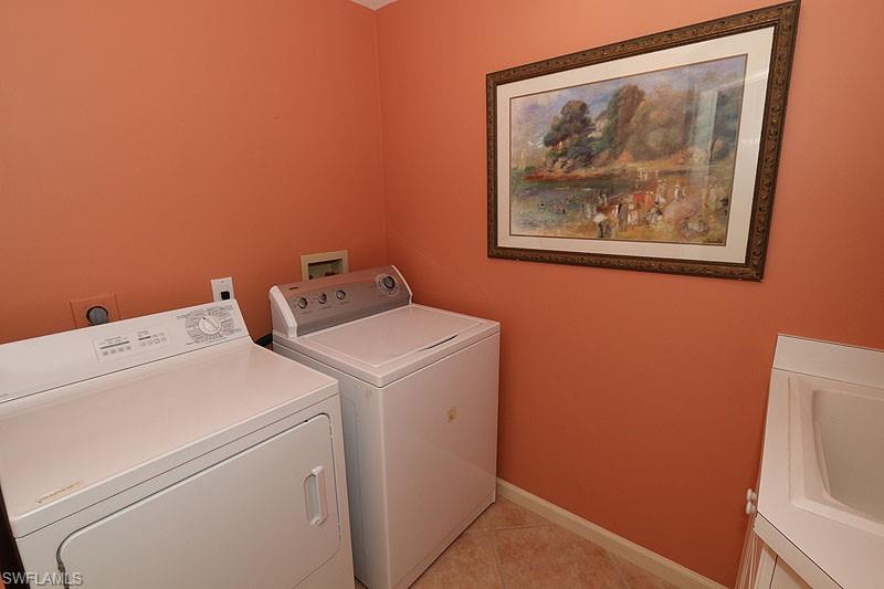 Dedicated laundry area featuring a white top-load washer and front-load dryer