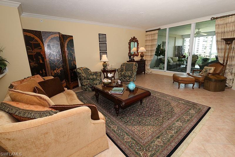 Spacious living area featuring neutral-toned walls and crown molding