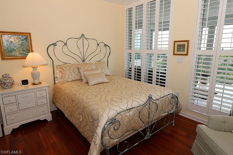 Hardwood flooring complements a decorative metal bed frame
