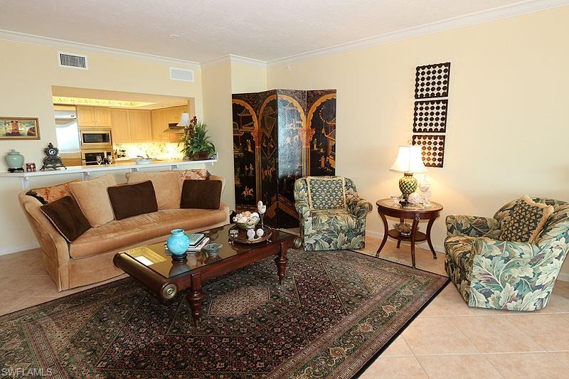 Living area featuring neutral wall tones, crown molding, and tiled flooring