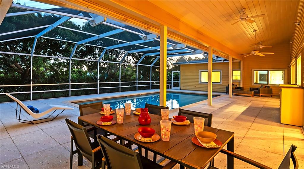 Swimming pool with a lanai, a patio, a sunroom, an outdoor hangout area, and outdoor dining area