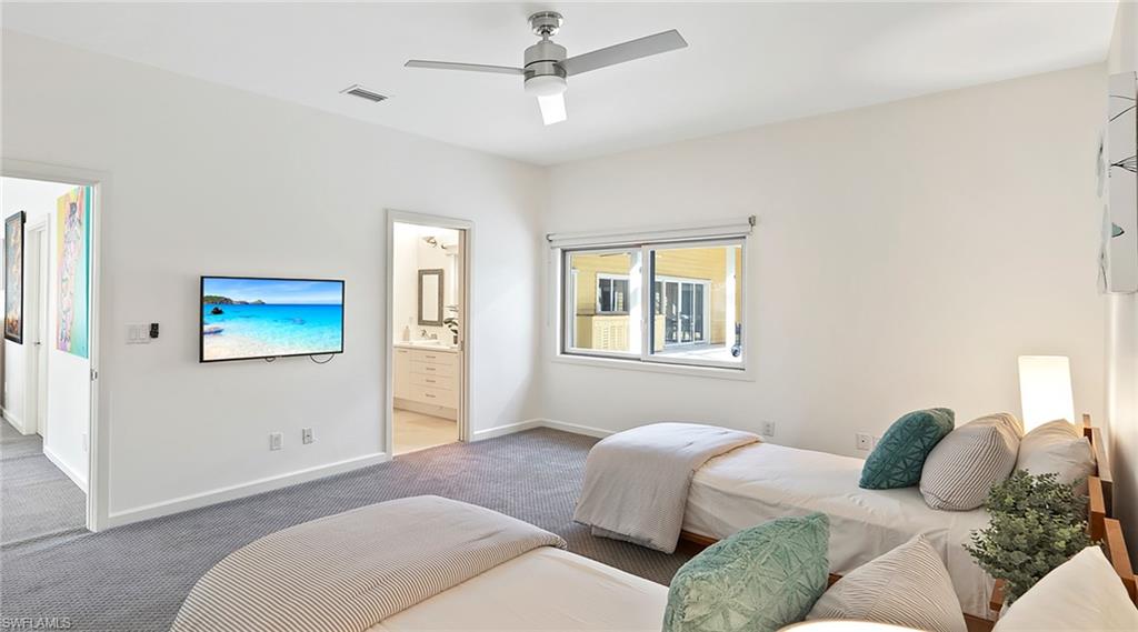 Bedroom featuring a ceiling fan, carpet flooring, and ensuite bath
