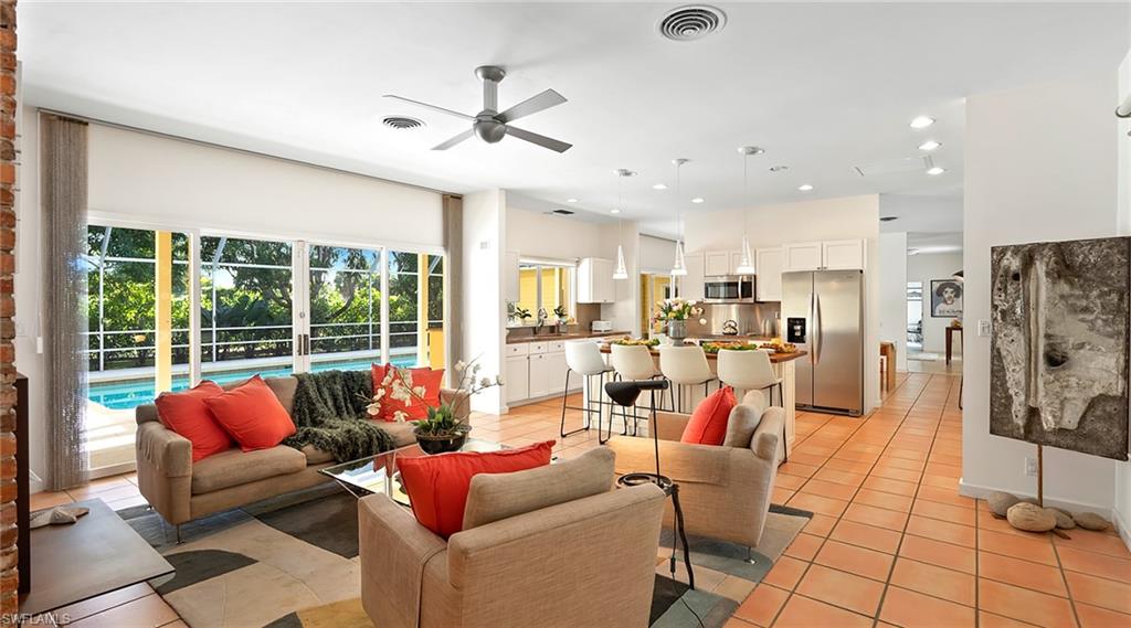 Living area with light tile patterned floors, ceiling fan, and recessed lighting