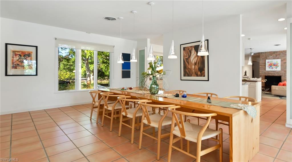 Dining area with light tile patterned flooring and a brick fireplace