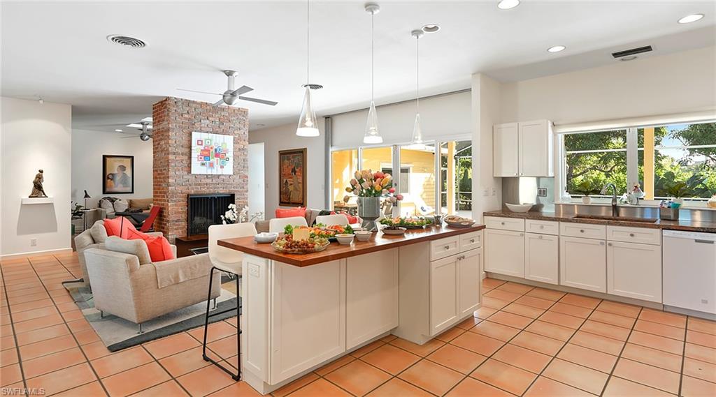Kitchen featuring pendant lighting, a kitchen breakfast bar, dishwasher, plenty of natural light, and recessed lighting