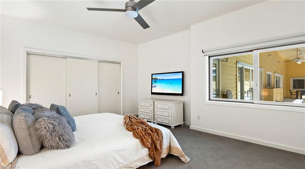 Carpeted bedroom with a closet and a ceiling fan