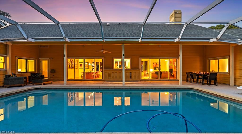 Swimming pool with a sunroom, a lanai, a patio, and outdoor dining area