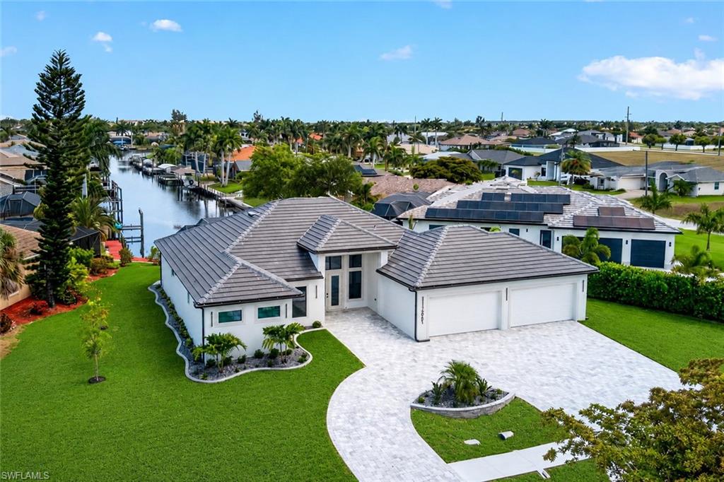 Modern exterior featuring a tile roof, a two-car garage, and a paver driveway
