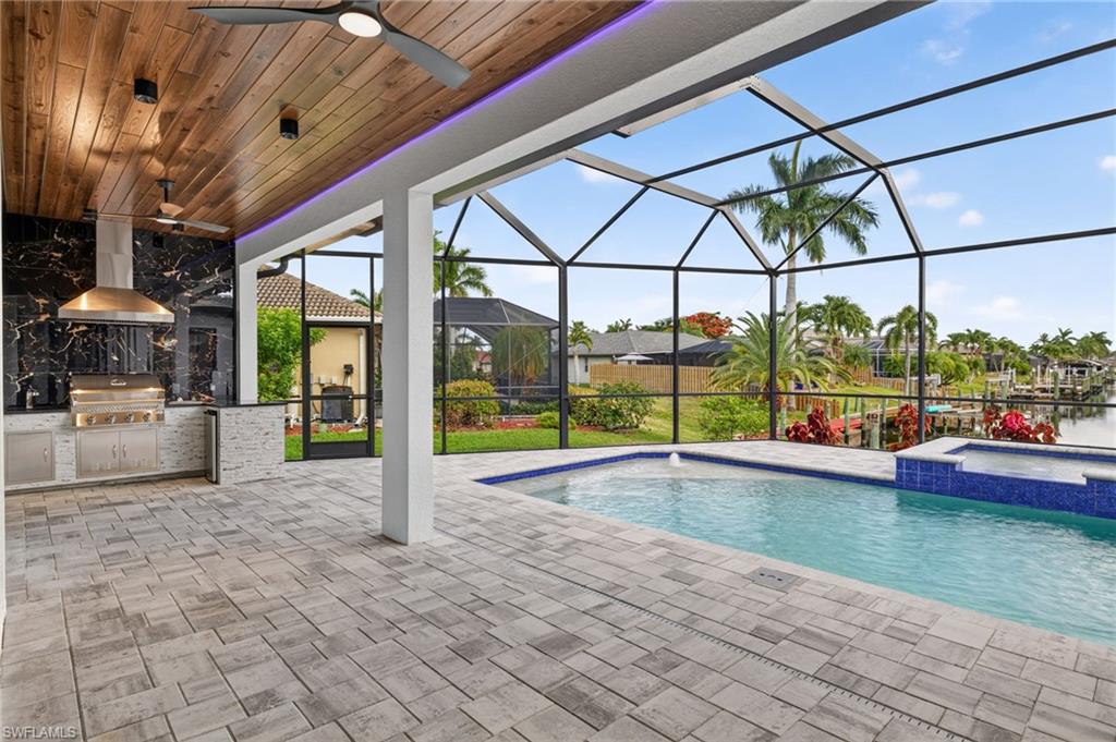 Covered outdoor living space featuring a wood-panel ceiling with recessed lighting and a ceiling fan