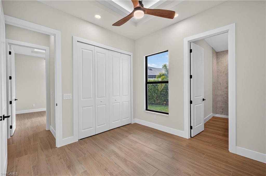 Room with wood-look tile flooring, white walls, and a contemporary ceiling fan