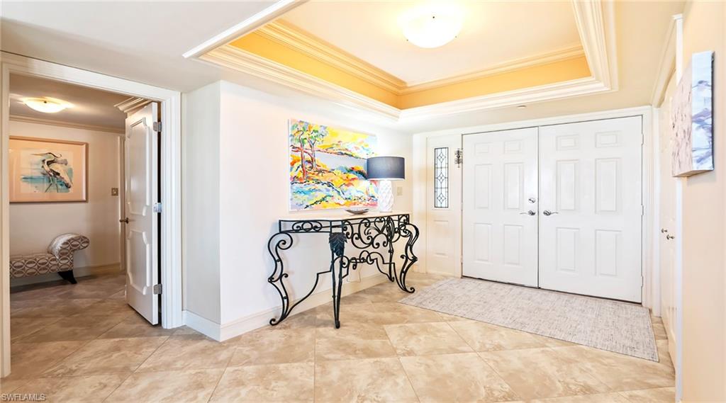 Entrance foyer featuring crown molding and light tile patterned floors