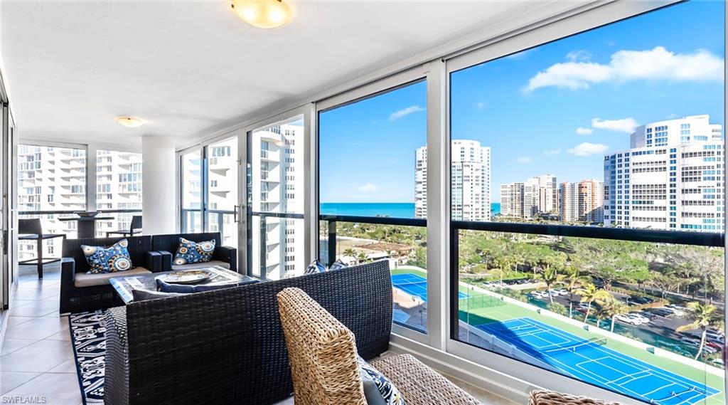 Sunroom with a view of city, healthy amount of natural light, tile patterned floors, floor to ceiling windows, and a water view