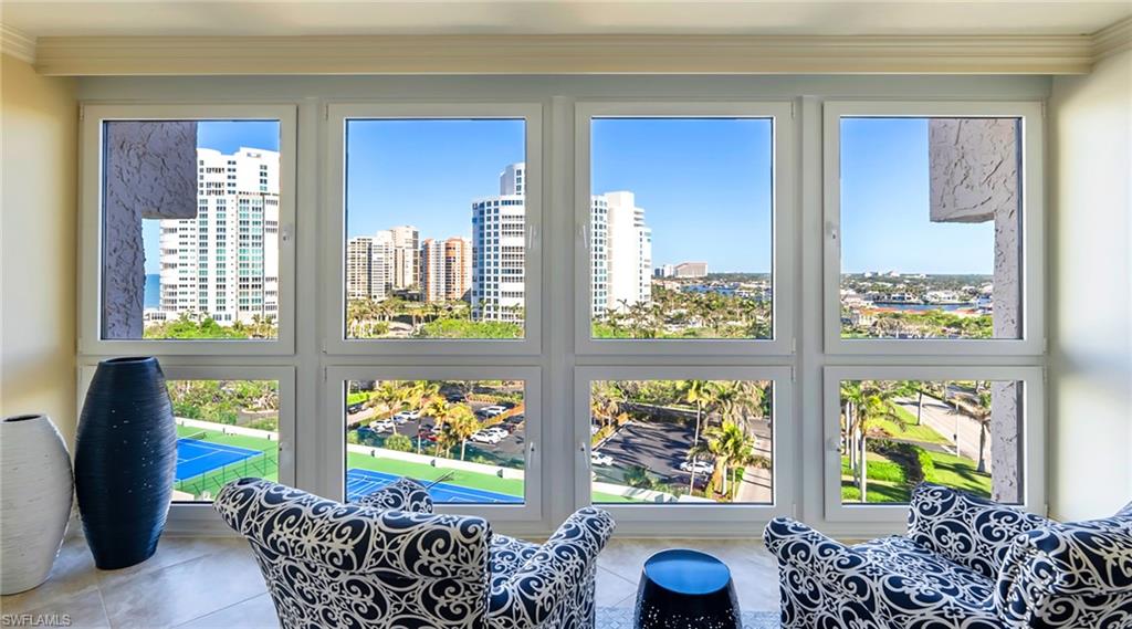 Sunroom / solarium featuring a city view, ornamental molding, plenty of natural light, and tile patterned flooring