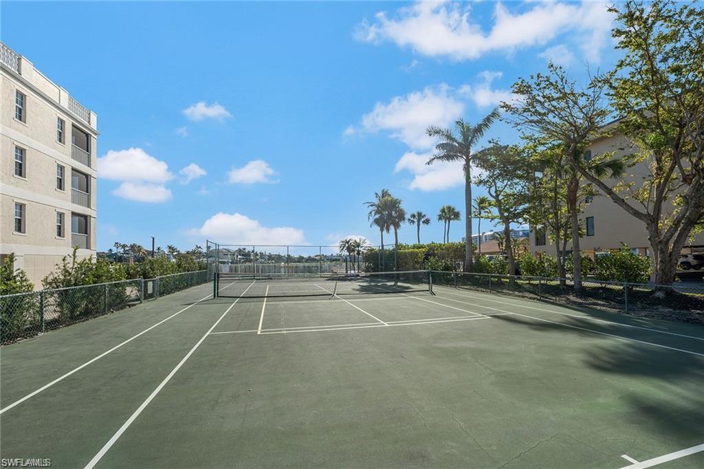 Full-size tennis court with a green surface and white line markings
