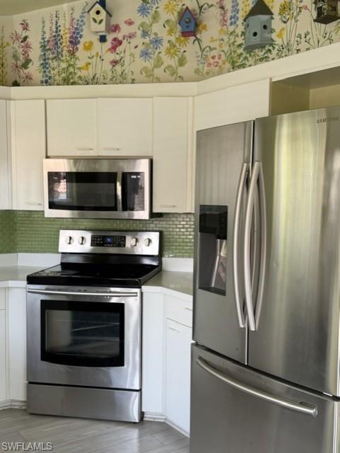 Kitchen featuring stainless steel appliances including a refrigerator, range, and built-in microwave