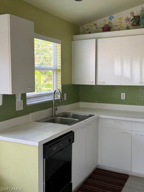 Kitchen featuring white cabinetry, a double basin stainless steel sink, a black built-in dishwasher, and a green mosaic tile backsplash