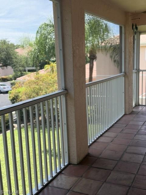 Screened balcony featuring square terracotta floor tiles and white vertical railings