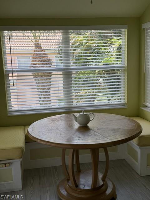 Bright corner with built-in seating featuring window blinds and wood-finish flooring