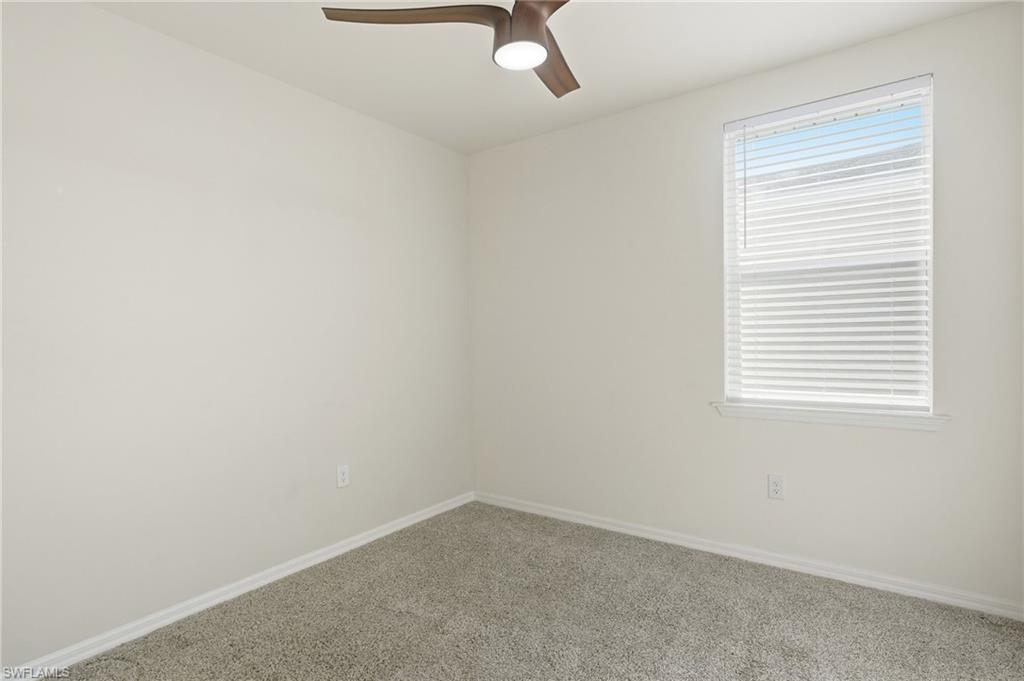 Room featuring light gray carpet, white painted walls, and a single window with horizontal blinds