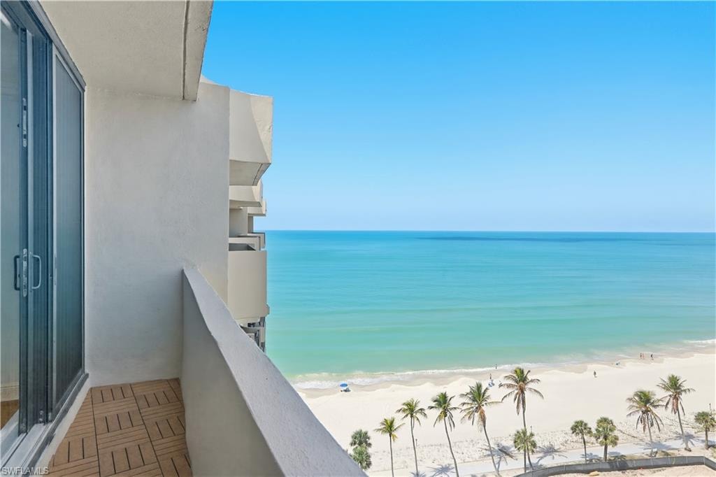 Balcony featuring view of water and beach