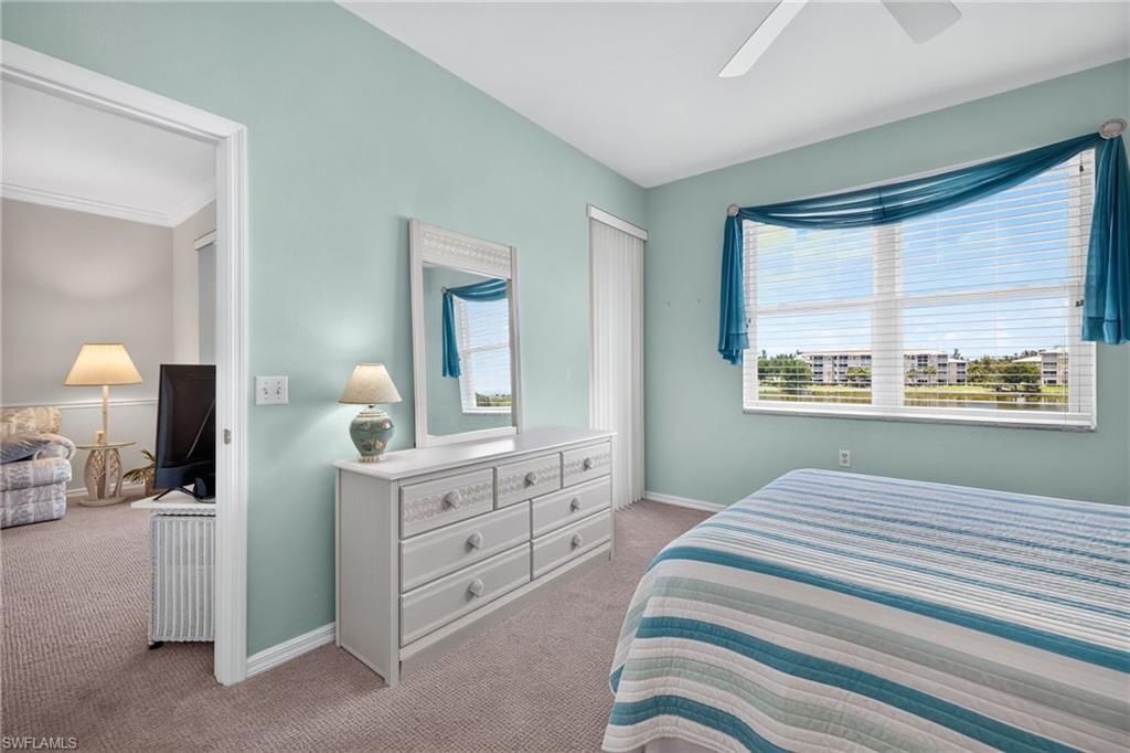 Bedroom featuring a window with horizontal blinds, light blue walls, and carpet flooring