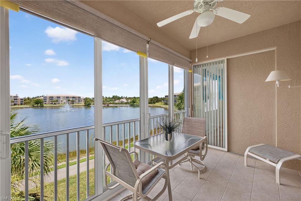 Screened balcony featuring expansive water frontage with a fountain, a textured ceiling with a ceiling fan, and sliding glass door access