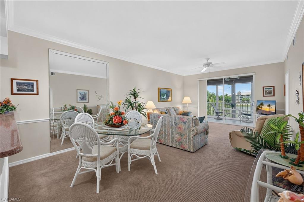 Open-concept living area featuring neutral walls and crown molding