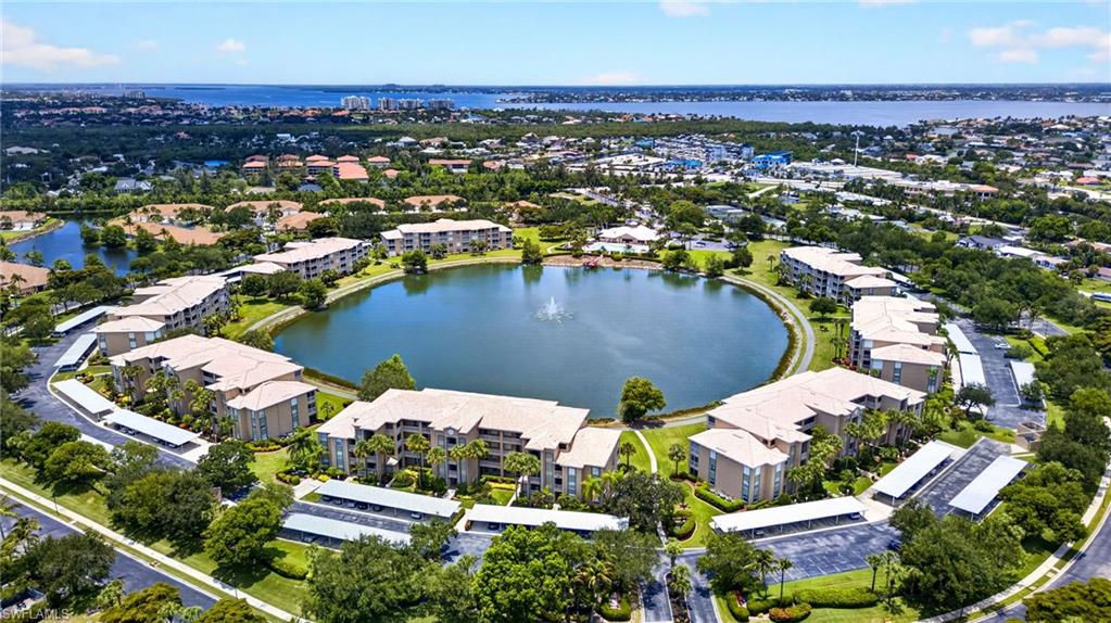 Residential community featuring multiple low-rise buildings encircling a central lake with a fountain