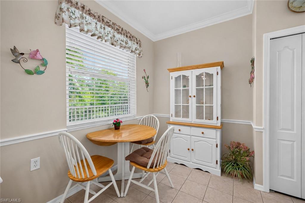 Dining area with a window featuring horizontal blinds and a floral valance
