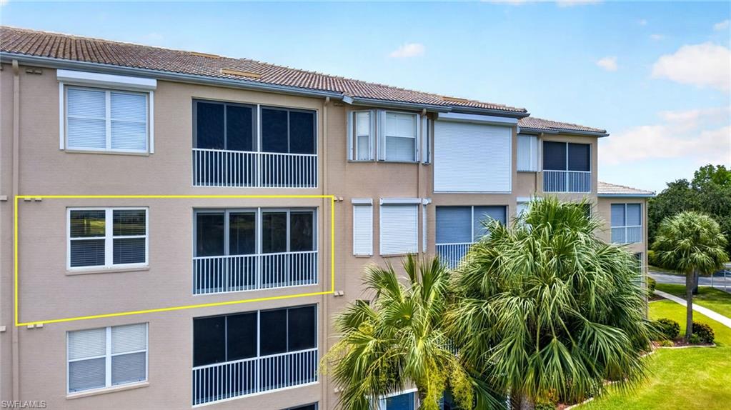 Mid-level unit featuring a multi-pane window and an enclosed balcony with white railings