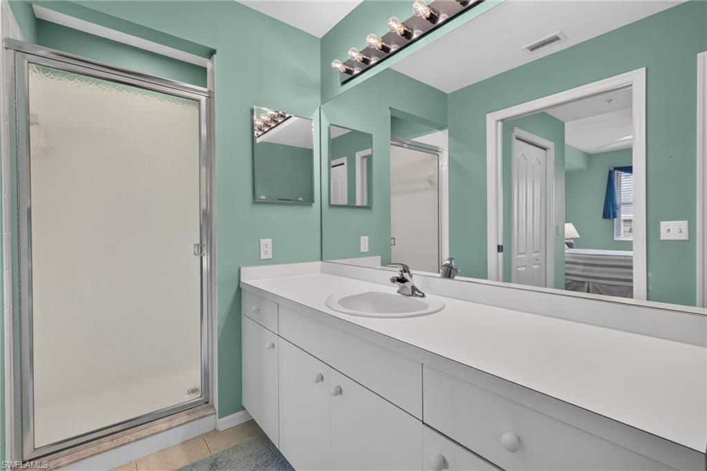 Bathroom featuring a white vanity with integrated sink, chrome faucet, and ample countertop space
