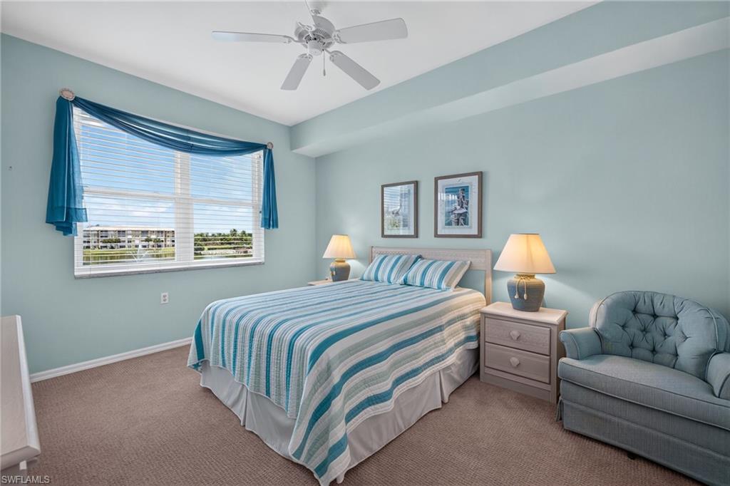 Comfortable bedroom space featuring a window with horizontal blinds, a ceiling fan, and carpeted flooring