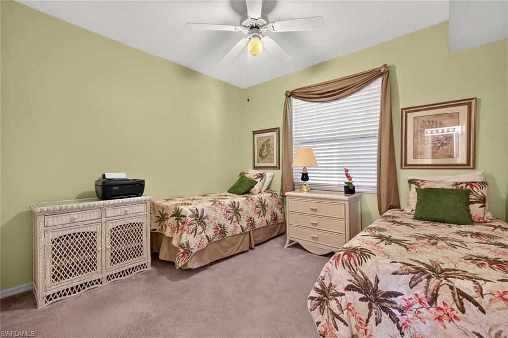 Carpeted room featuring a ceiling fan, a window with blinds and drapery, and neutral wall tones