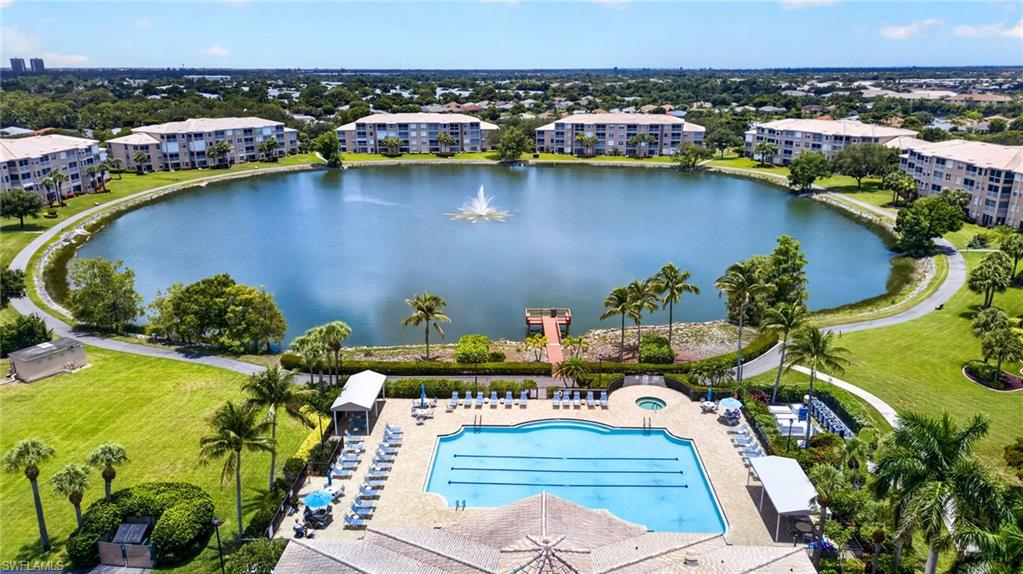Expansive aerial view showcasing a large central lake with a fountain, surrounded by multiple residential buildings