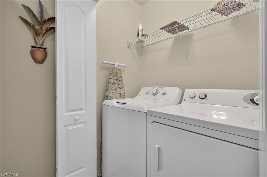 Dedicated laundry area featuring a washer and dryer, wire shelving, and a wall-mounted towel bar
