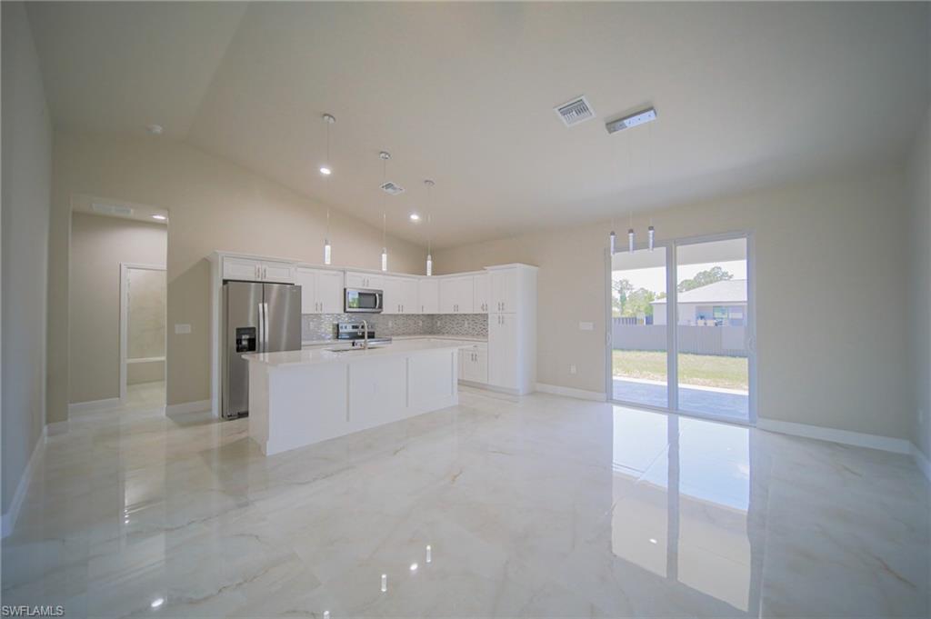 Oversized Living Room With View Into The Kitchen And Dining Area With Dual Hurricane Sliders That Lead Out To A Covered Lanai!