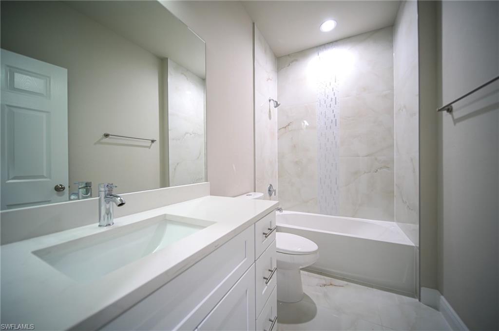 Full bathroom featuring vanity,  shower combination, recessed lighting, toilet, and marble finish floor