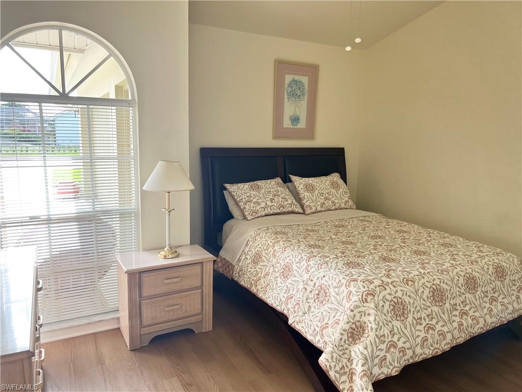 Bedroom with multiple windows and hardwood / wood-style floors