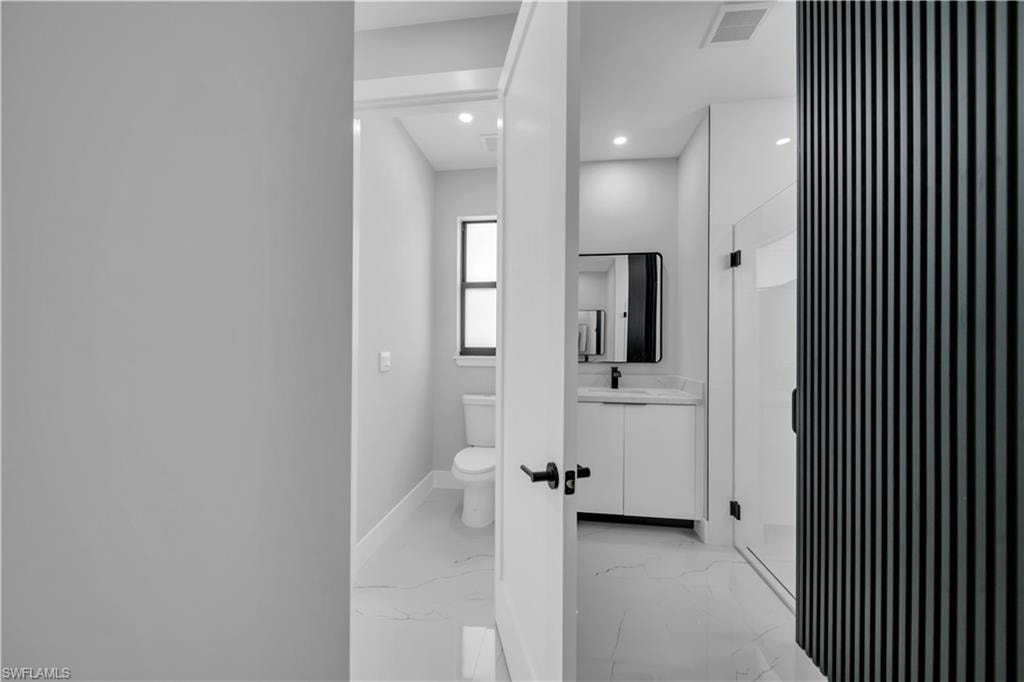 Modern bathroom featuring a white vanity with a rectangular sink, black framed mirror, and matte black faucet