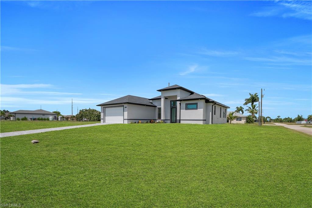 Contemporary stucco exterior with a multi-gabled roofline, integrated garage, and a prominent entryway