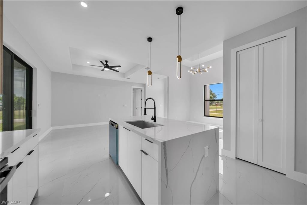 Kitchen island with a waterfall-edge countertop and integrated sink, featuring contemporary pendant lighting
