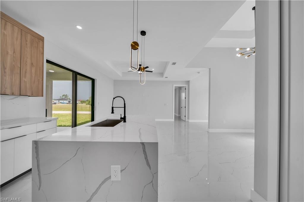 Kitchen island with waterfall edge, integrated sink, and matte black faucet
