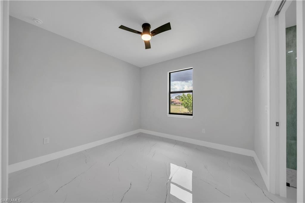 Room featuring large format tile flooring, a dark-framed window, and a ceiling fan with integrated lighting
