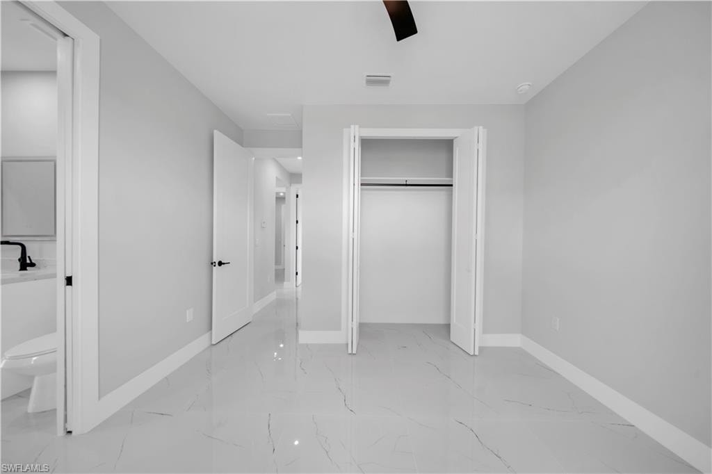 Interior room featuring light gray walls, white baseboards, and a contemporary ceiling fan